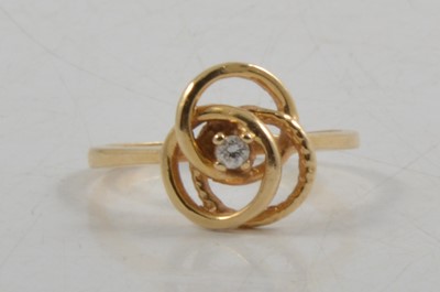 Lot 272 - A diamond set knot design dress ring.