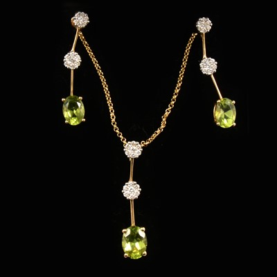 Lot 132 - A peridot and diamond pendant and earring suite.