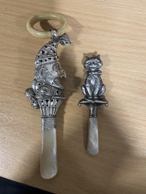 Lot 158 - A silver, ivory and mother-of-pearl 'jester' baby rattle, and a silver teether.