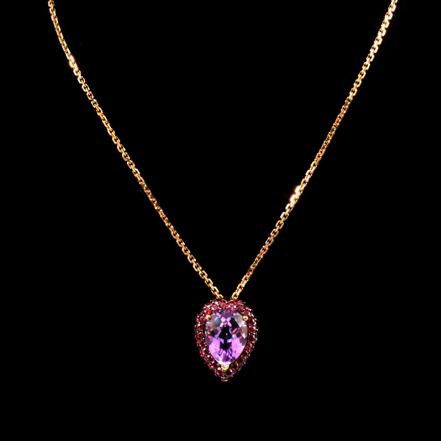 Lot 129 - An amethyst and pink stone pendant on 9 carat yellow gold chain.