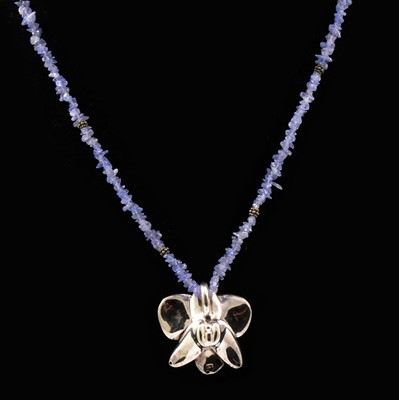 Lot 203 - A tanzanite necklace with silver flower pendant, boxed.