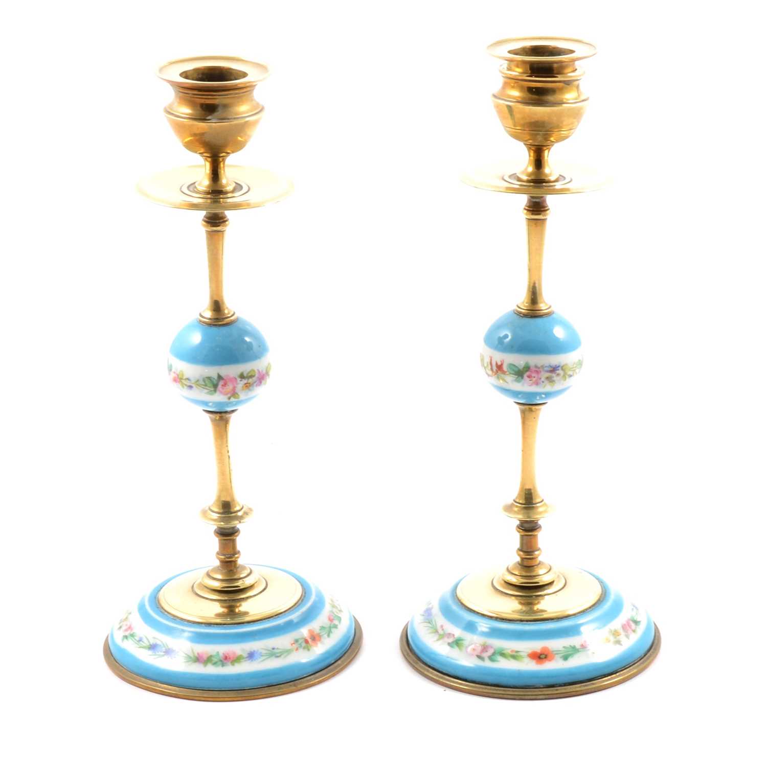 Lot 22 - A pair of brass candlesticks with pale blue ceramic detail.