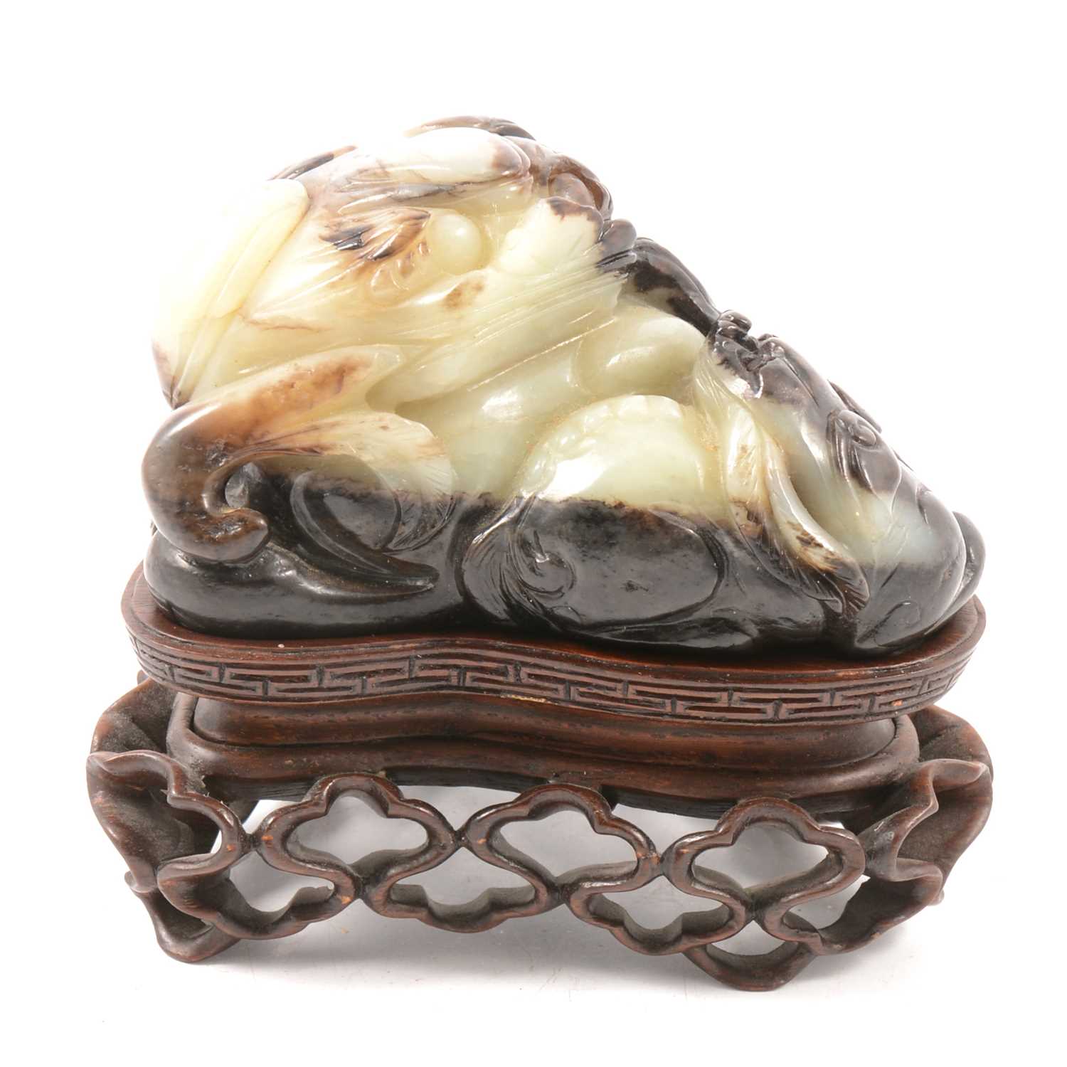 Lot 17 - Chinese green and russet jade carving of a recumbent lion
