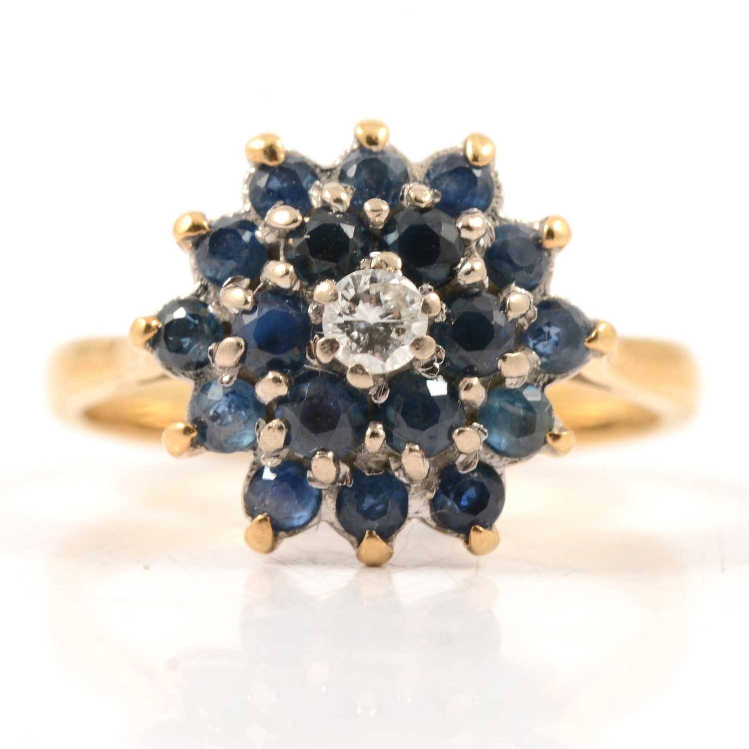 Lot 36 - A sapphire and diamond cluster ring.