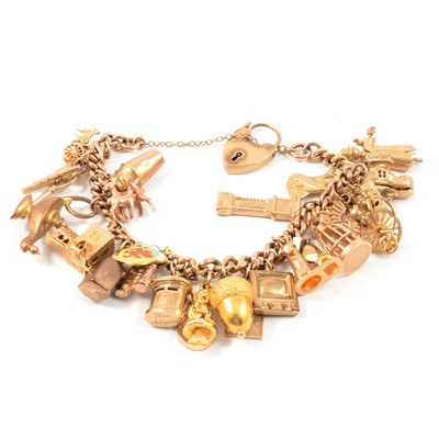 Lot 128 - A yellow metal hollow curb link bracelet with charms attached.