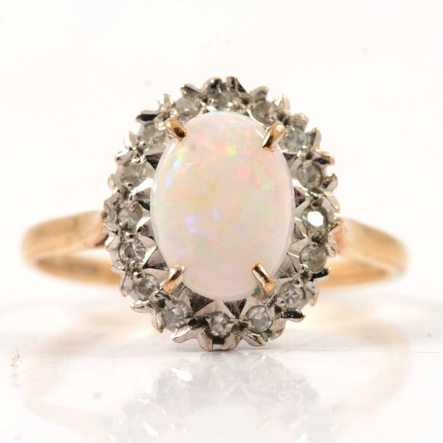 Lot 50 - An opal and diamond oval cluster ring.