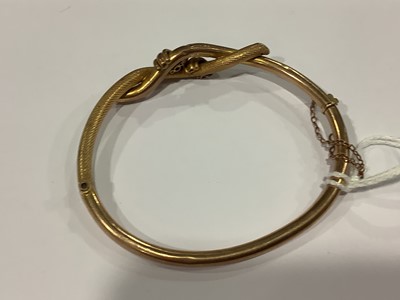 Lot 160 - A knot design hollow half hinged bangle.
