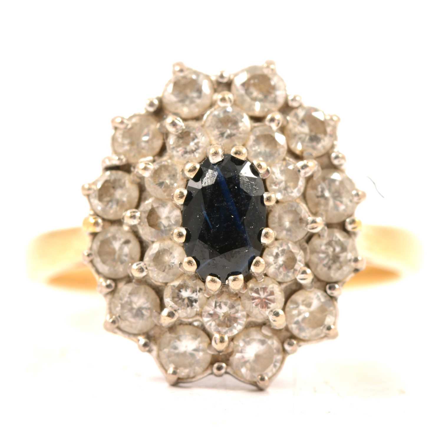 Lot 49 - A sapphire and diamond oval cluster ring.