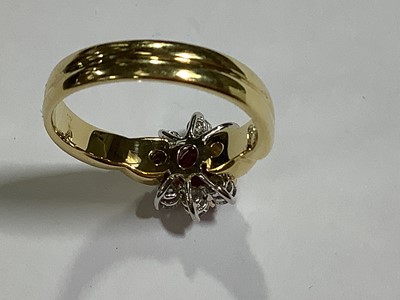 Lot 350 - A ruby and diamond circular cluster ring.