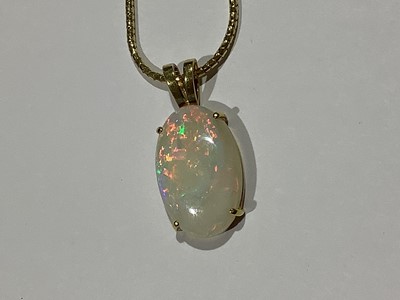 Lot 215 - An oval cabochon cut opal pendant and chain.