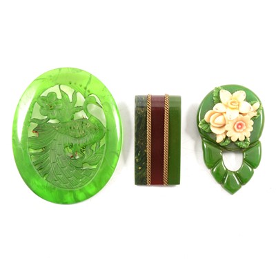 Lot 369 - Twenty apple green and green lucite, bakelite and ivorine brooches, dress clips and belt buckles.