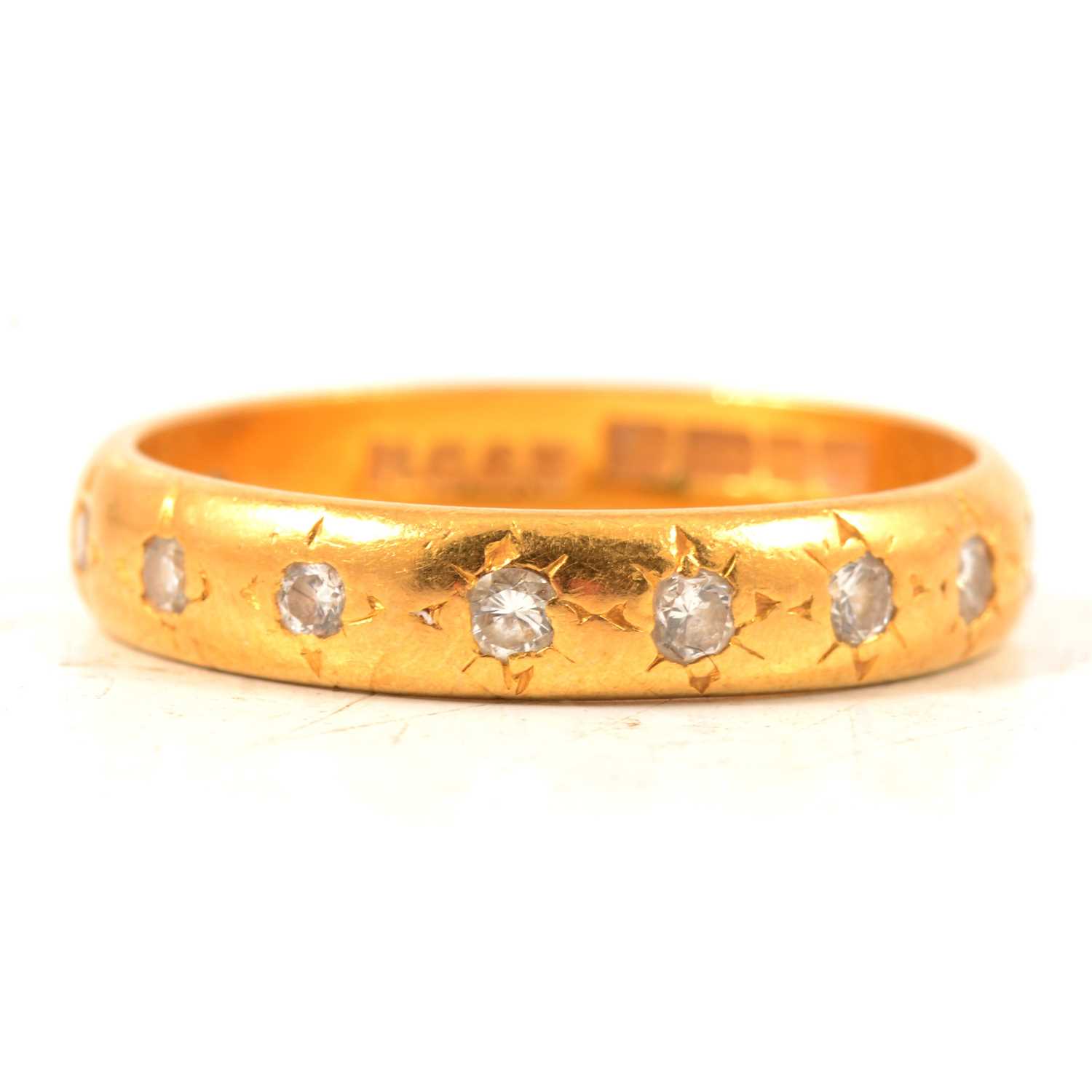 Lot 33 - A diamond three quarter eternity ring in 22 carat yellow gold.