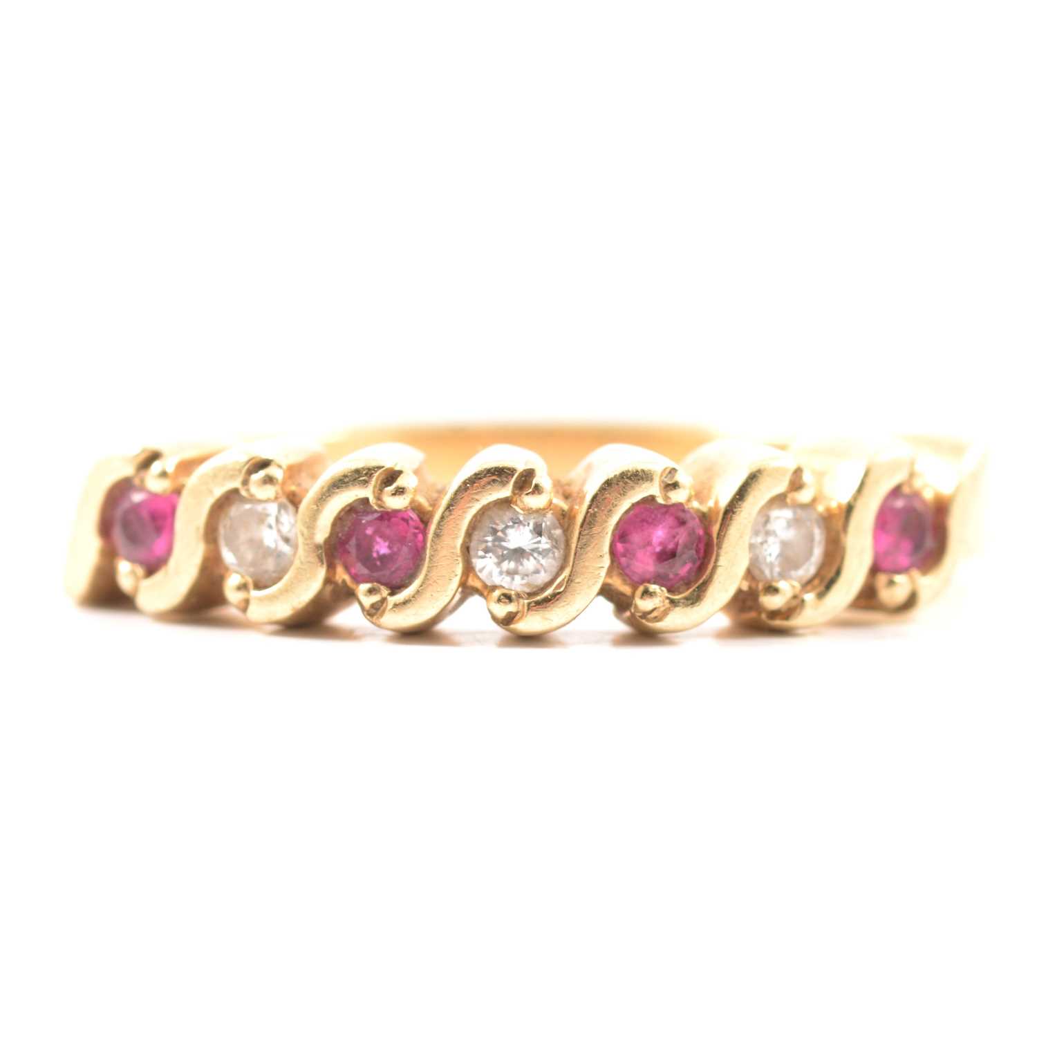 Lot 60 - A ruby and diamond half eternity ring.