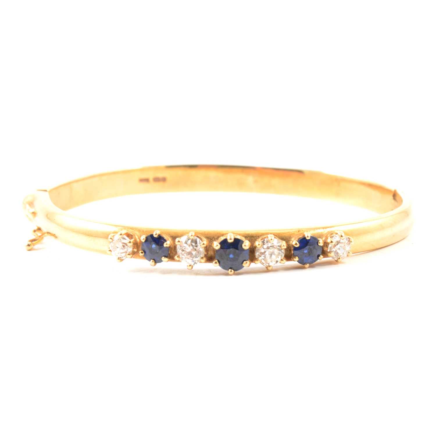 Lot 157 - A sapphire and diamond bangle.