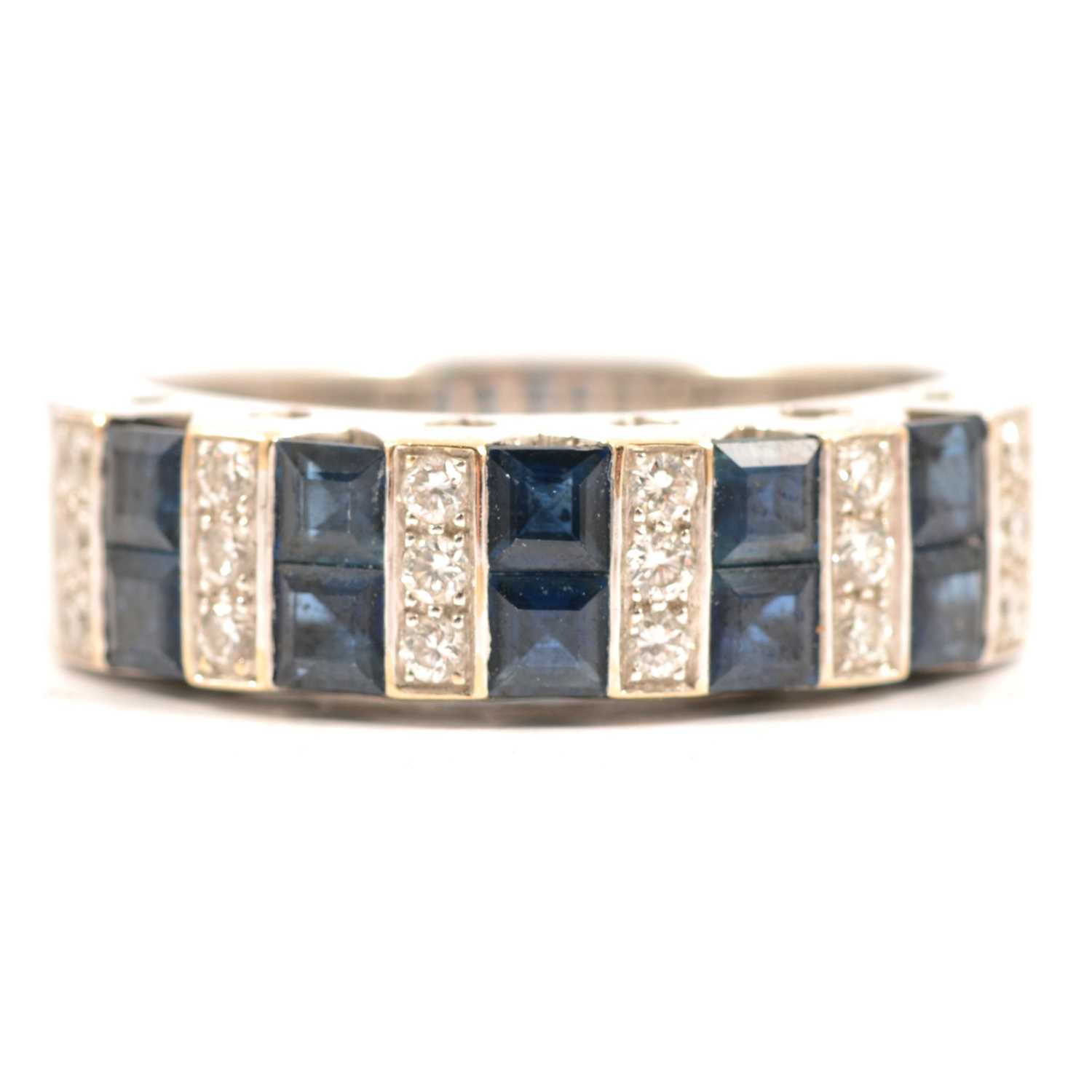 Lot 57 - A sapphire and diamond half hoop ring.