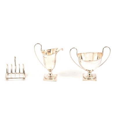 Lot 295 - Silver helmet cream jug and twin-handled sugar bowl, William Aitken, Birmingham 1915, and silver toast rack.