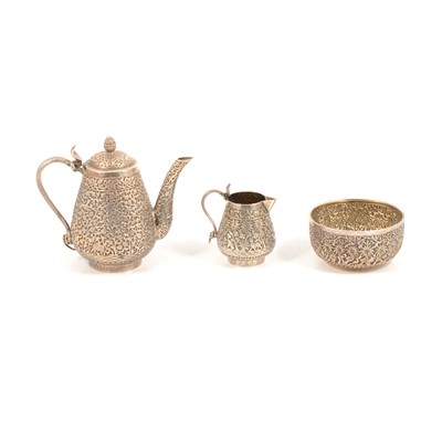 Lot 272 - Burmese style white metal milk jug and sugar basin, and a similar white metal teapot.