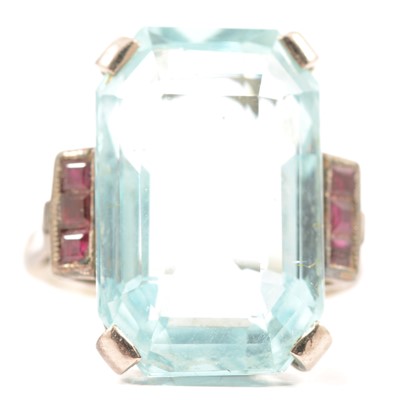 Lot 91 - An aquamarine ring with ruby shoulders.