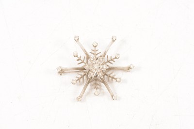 Lot 200 - A modern 18 carat white gold diamond set snowflake star brooch.