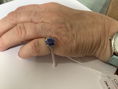 Lot 45 - A sapphire ring with two baguette cut diamonds in each shoulder.
