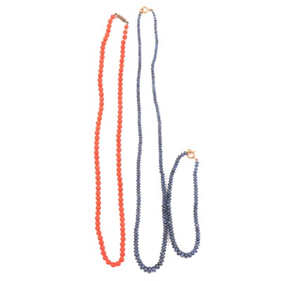 Lot 287 - A sapphire tumblestone necklace, matching bracelet and coral necklace with diamond clasp.