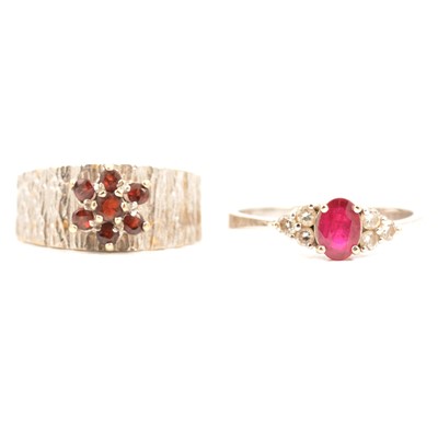 Lot 76 - A ruby and diamond three stone ring and a garnet ring.