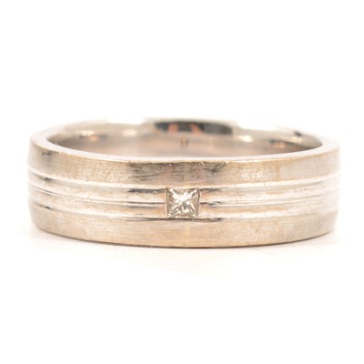 Lot 38 - An 18 carat white gold band set with a small princess cut diamond.