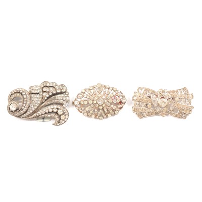 Lot 464 - Twelve Art Deco and later clear paste set brooches.