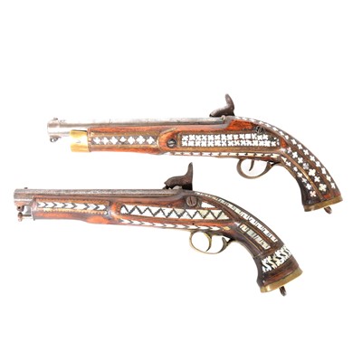 Lot 128 - Two percussion pistols, with Eastern mother-of pearl decoration and brass mounts.