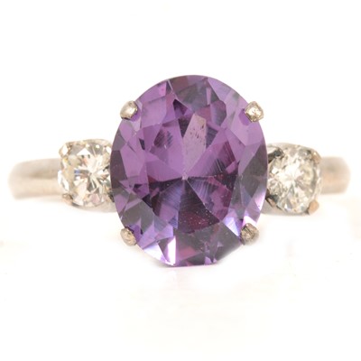 Lot 317 - A purple synthetic corundum and diamond three stone ring.