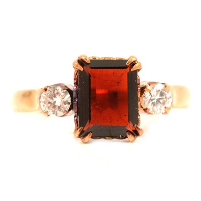 Lot 105 - A garnet and diamond three stone ring.