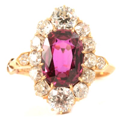 Lot 59 - A ruby and diamond cluster ring.