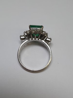 Lot 72 - An emerald and diamond ring.