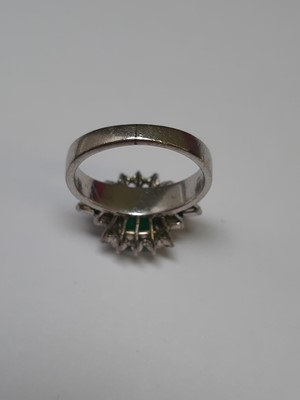 Lot 72 - An emerald and diamond ring.