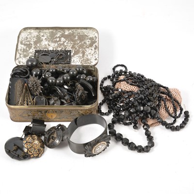 Lot 260 - A collection of jet and similar jewellery in a vintage tin.