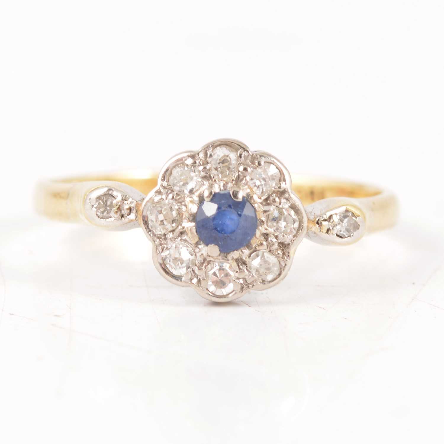 Lot 236 - A sapphire and diamond cluster ring.