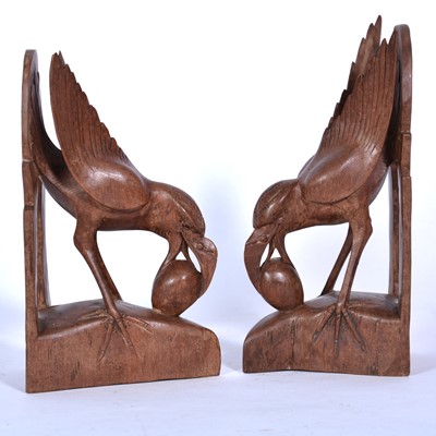Lot 126 - Pair of carved wooden bookends, exotic bird with egg in beak.