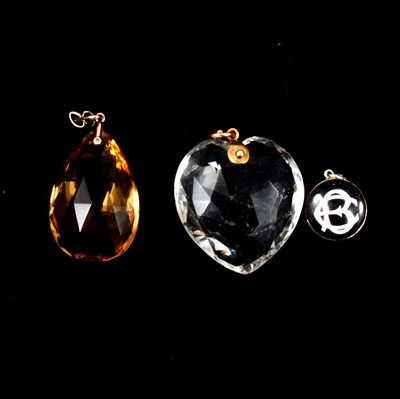 Lot 403 - A citrine pendant, a paste crystal heart pendant and monogrammed pendant.