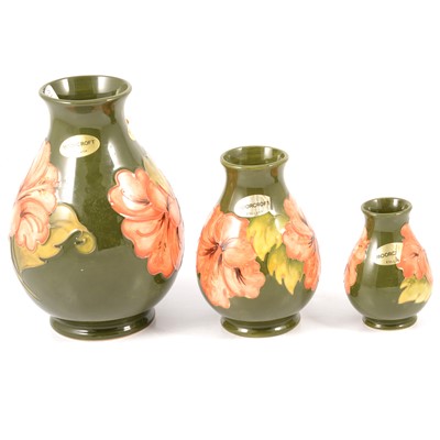 Lot 29 - Moorcroft Pottery - three graduated Hibiscus pattern vases.