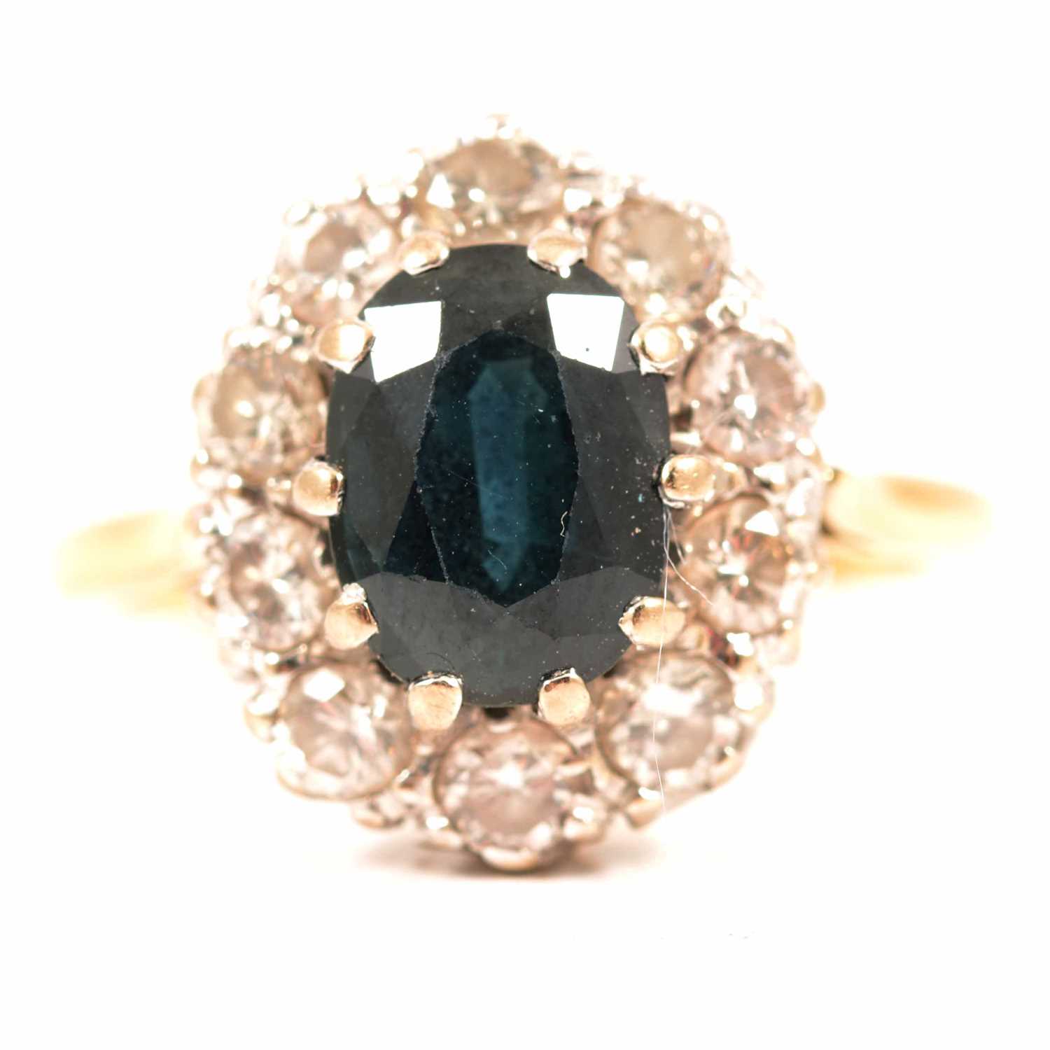 Lot 45 - A sapphire and diamond oval cluster ring.