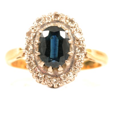 Lot 46 - A sapphire and diamond oval cluster ring.