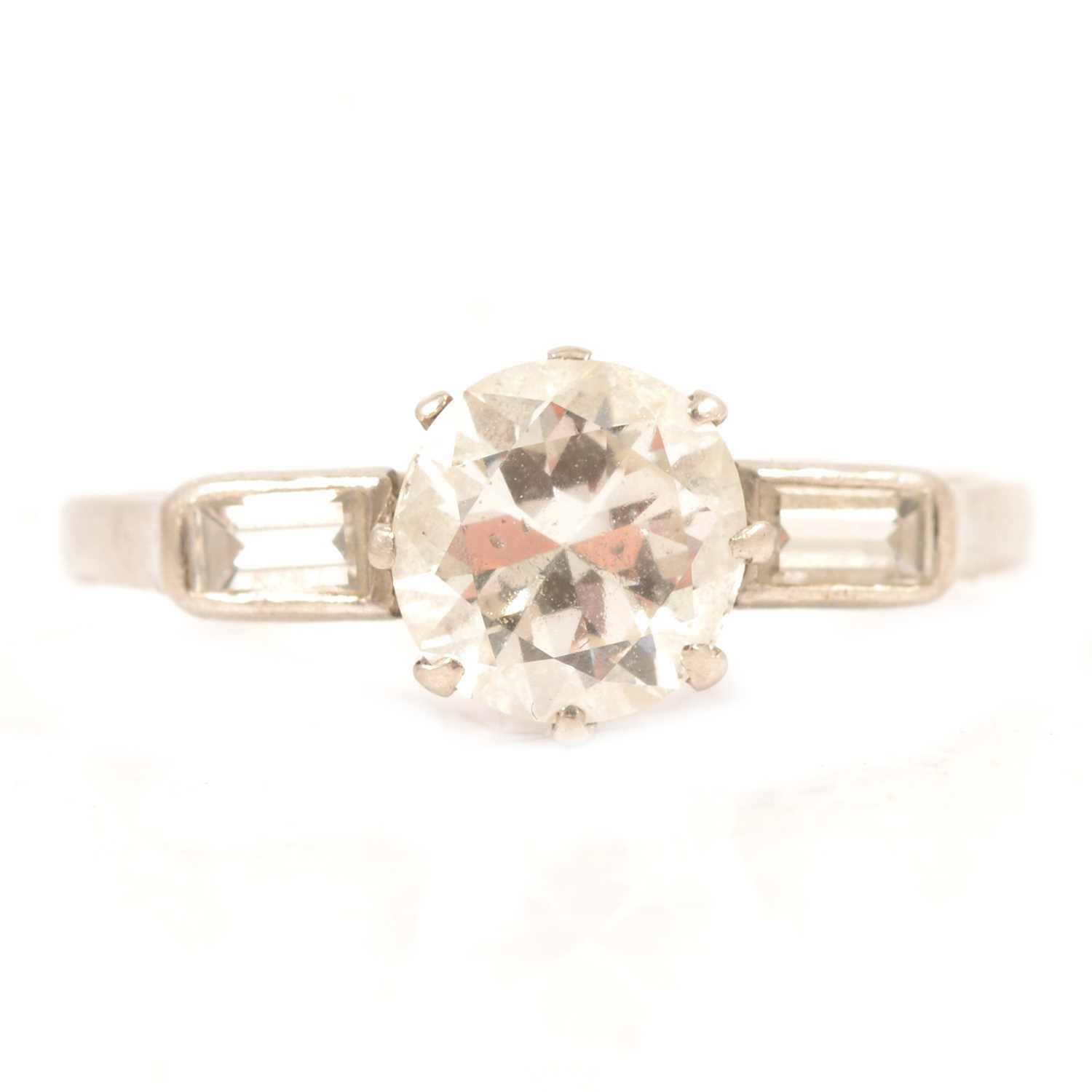 Lot 3 - A diamond solitaire ring with baguette cut shoulders.