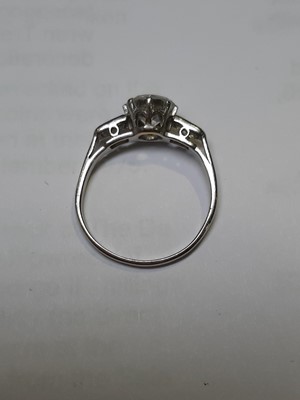 Lot 3 - A diamond solitaire ring with baguette cut shoulders.
