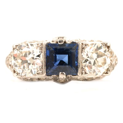 Lot 42 - Ellis Bros - A sapphire and diamond three stone ring in diamond set mount.