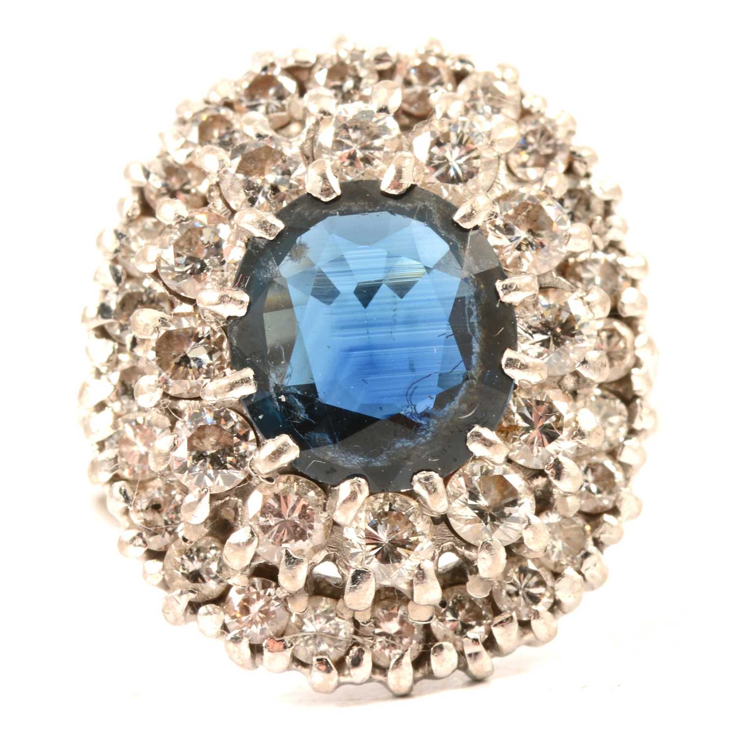 Lot 44 - A sapphire and diamond oval cluster ring.