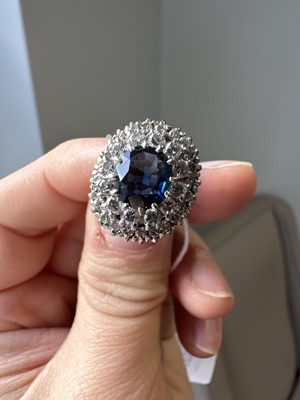 Lot 44 - A sapphire and diamond oval cluster ring.