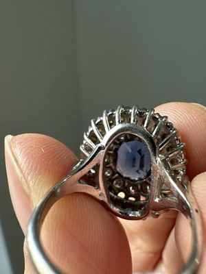 Lot 44 - A sapphire and diamond oval cluster ring.