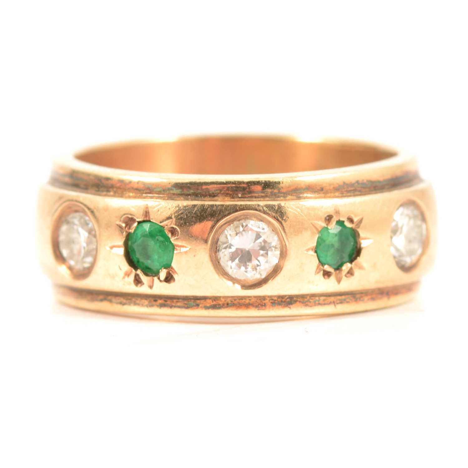 Lot 75 An emerald and diamond gypsy set ring.