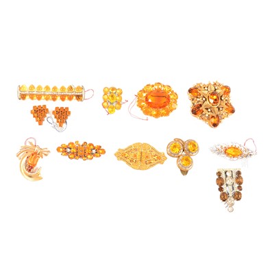 Lot 415 - Twelve Art Deco and later faux topaz paste dress clips and brooches.