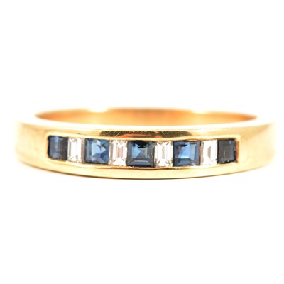 Lot 53 - A sapphire and diamond half eternity ring.